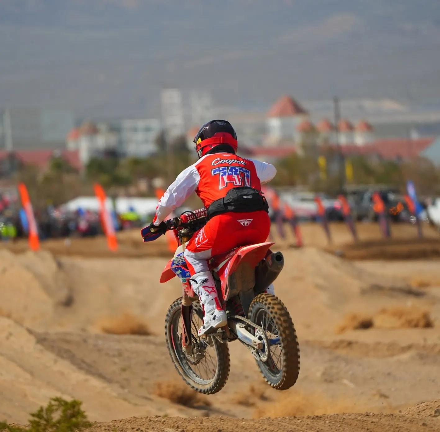 A Rogue 7 Racing rider on a red Honda at speed through the Nevada desert
