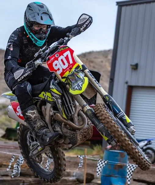 Justin Wallis jumping the number 907 bike in black gear