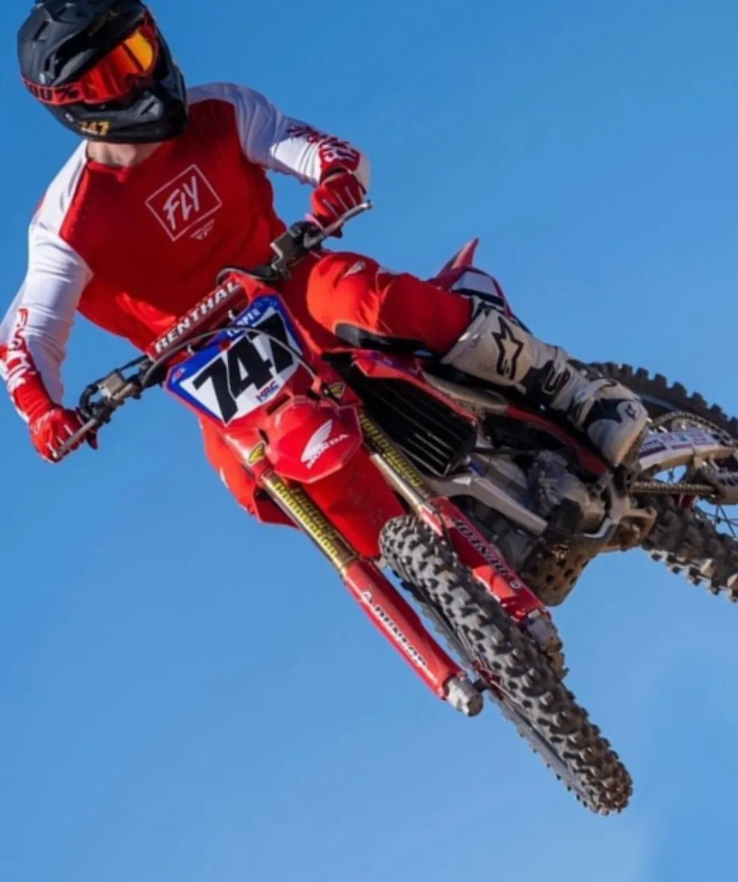 Wyatt Cooper mid-air on the number 747 Honda in red and white gear